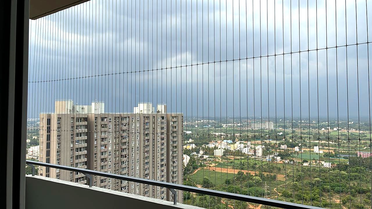 Invisible grill on a high-rise balcony with an open city view
